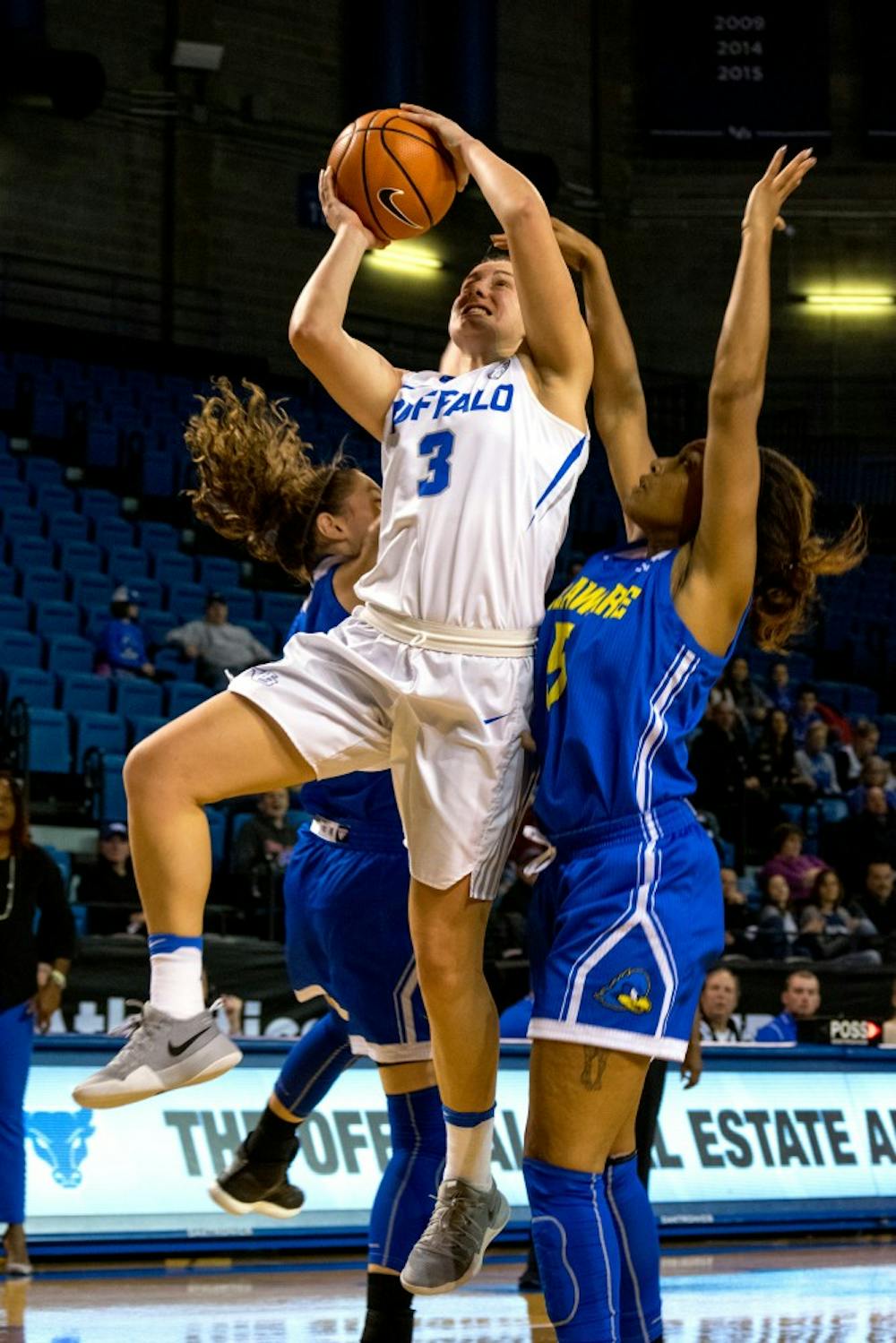 <p>Senior guard Lisa Ups works around two Kent State defenders to make a layup. The Bulls beat Kent State 80-42 at home on Wednesday.</p>