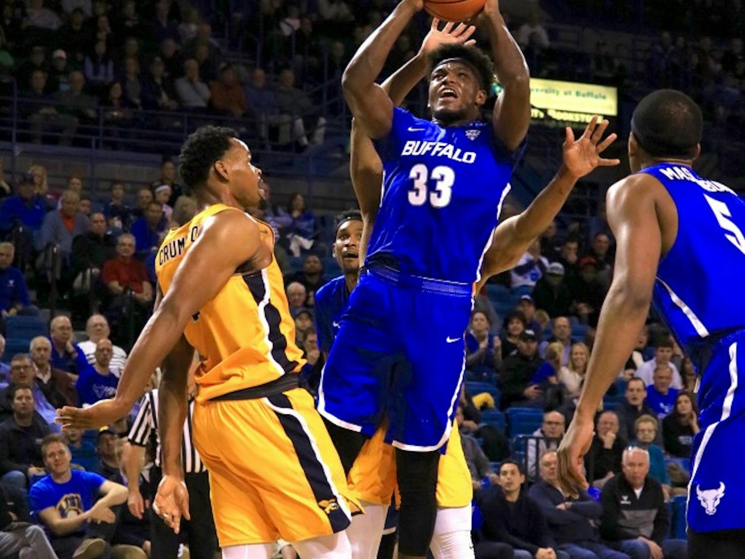 Junior forward Nick Perkins goes up for a shot in between two defenders. Perkins has been a force in the paint for the Bulls so far this season. 