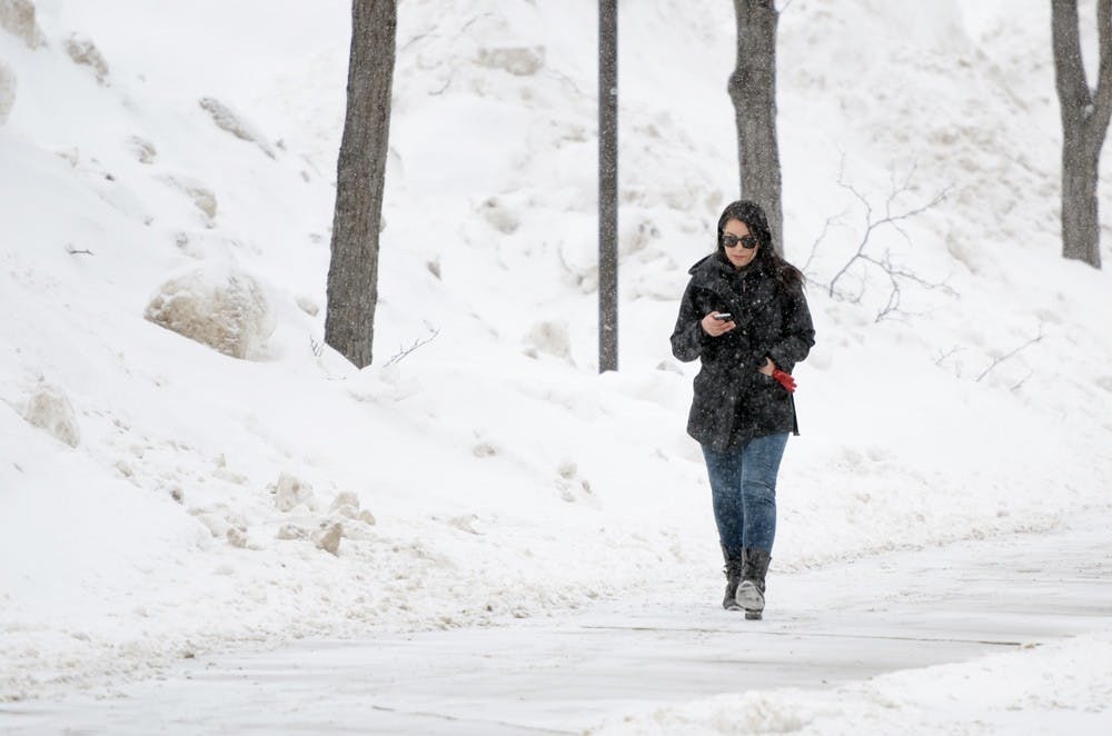 <p>Stock photo of&nbsp;Angelica Rochford, a junior social sciences interdisciplinary major, walking through the snow on North Campus last winter. UB will open on-campus housing early in order to accommodate students traveling from the New York City area, which will be hit by Winter Storm Jonas.&nbsp;</p>