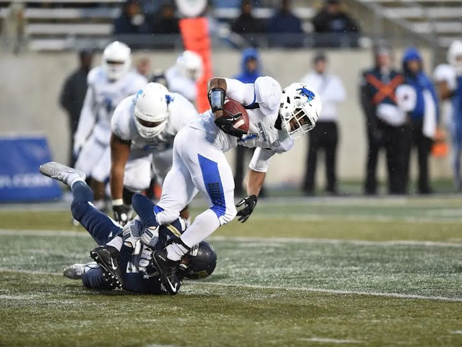 Senior running back Anthone Taylor gets tripped up by an Akron defender in Buffalo's 42-21 loss Saturday. The Bulls will head into their season finale against Massachusetts next week needing a win for any chance at a bowl game. 