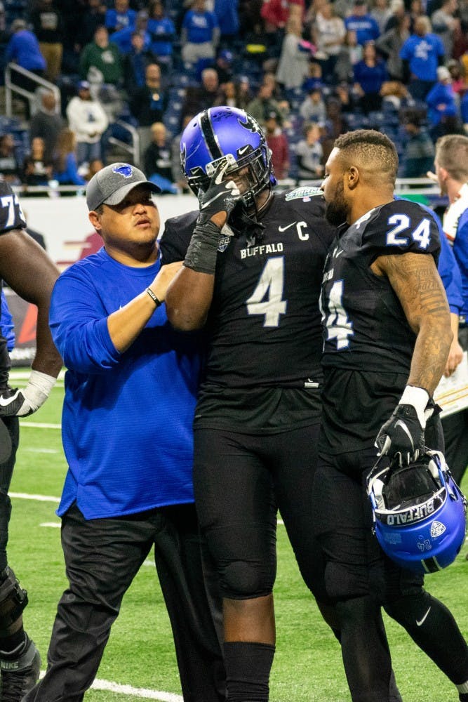 Hodge walks off Ford Field at the MAC Championship game. Written on the wrap around his wrist is "10/29" and "12/3," his brother’s birthday and death day.