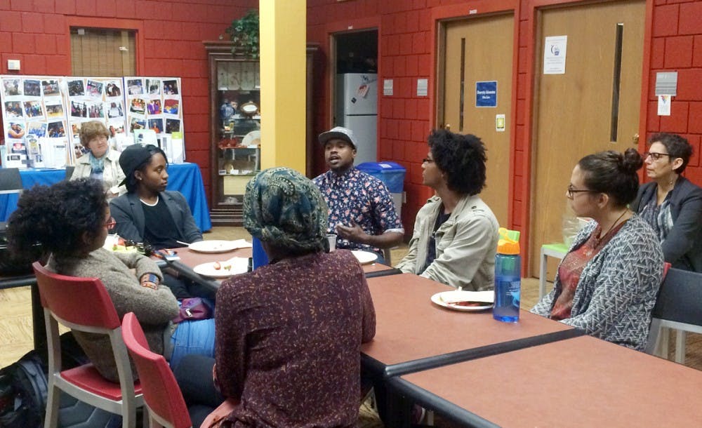 <p>Tiq Milan (center)&nbsp;met with UB students to discuss what it means to be transgendered and how improper healthcare for those who identify this way can be dangerous. He spoke for about an hour and then engaged with students directly, taking suggestions about how UB can become more transgender-friendly.</p>