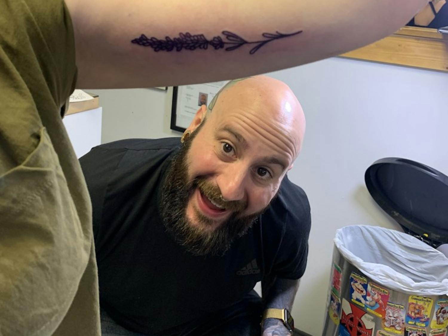 Tattoo artist Marc Lavey admires his flash tattoo on UB alumni Rachel Robert at CowPok Piercing and Tattoos’ annual fundraiser.