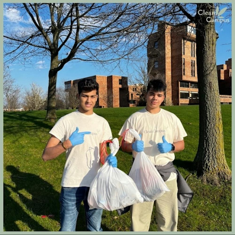 Chirag Ohiri (right) and Aryan Mudgal (left) doing a campus cleanup near the Ellicott Complex.