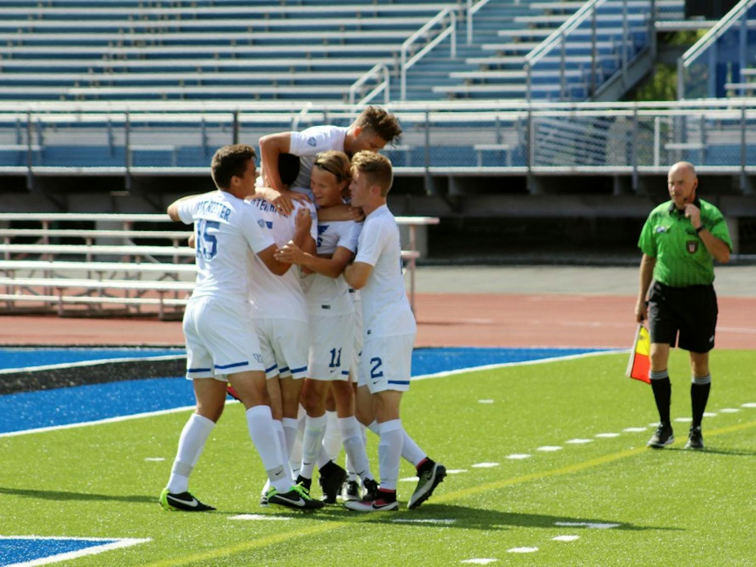 The men’s soccer team celebrates after a game. The men’s soccer team was one of four teams cut last month.