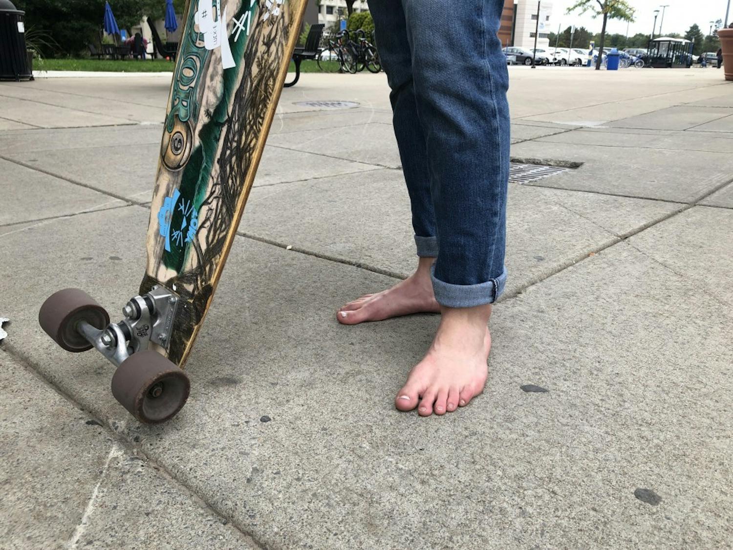 Romanyk, who stopped wearing shoes at the beginning of the semester after noticing another student riding his longboard without shoes, says going barefoot empowers him by helping "build his toughness."