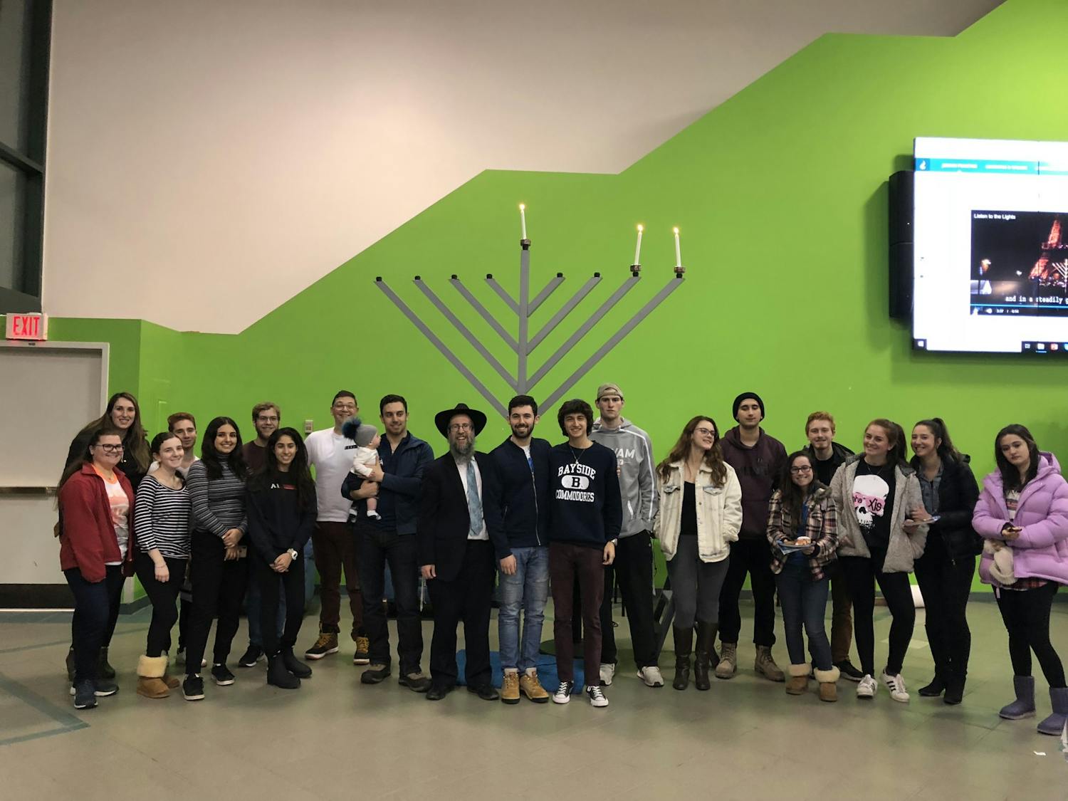 Jewish students pose in front of a menorah in the Student Union in December 2018.