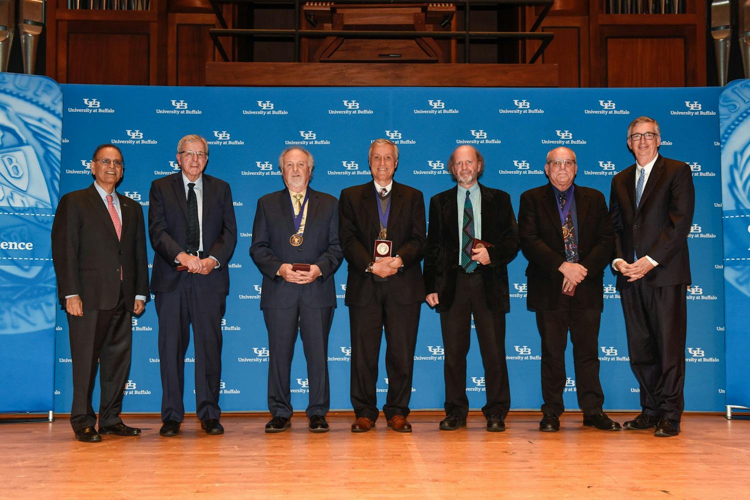 Interim Provost A. Scott Weber (far right) and President Satish Tripathi (far left) stand with 2019 SUNY Distinguished Professors.