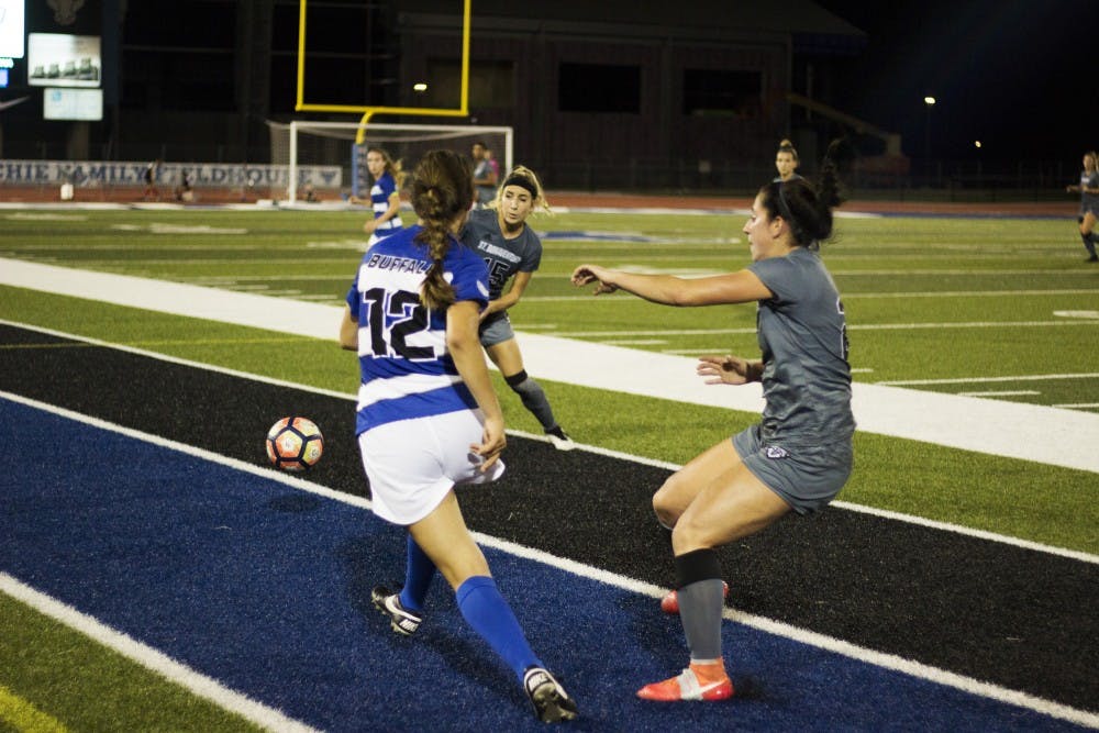 <p>Freshman midfielder Katherine Camper passes between two defenders. Soccer beat St. Bonaventure 3-1 as senior forward Carissima Cutrona and sophomore forward Marcy Barberic combined for nine points.</p>