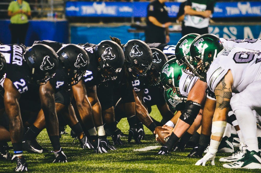 <p>The UB defensive line meets Eastern Michigan at the line of scrimmage. Senior defensive end Chuck Harris, wearing number 41, finished the best game of his collegiate career with eight tackles, two and a half sacks and a forced fumble.</p>
