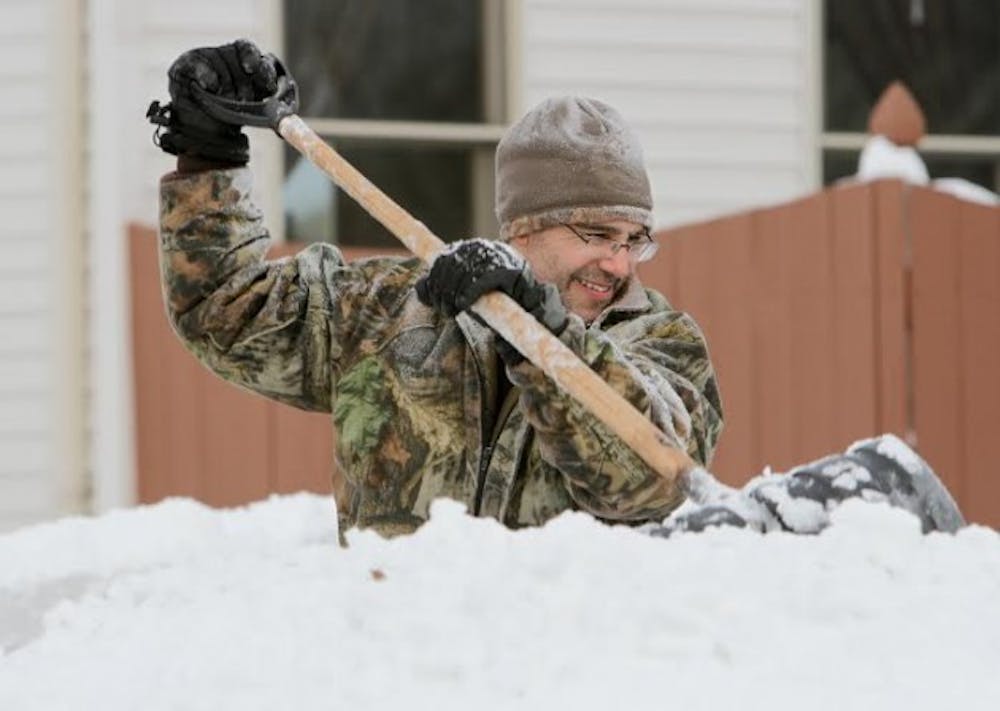 A man in Lancaster struggles to clear his driveway of the more than 60 inches of snow the Buffalo suburb recieved through Wedneday. Some students in the affected areas were frustrated UB didn&#39;t cancel classes before Thursday. Chad Cooper, The Spectrum