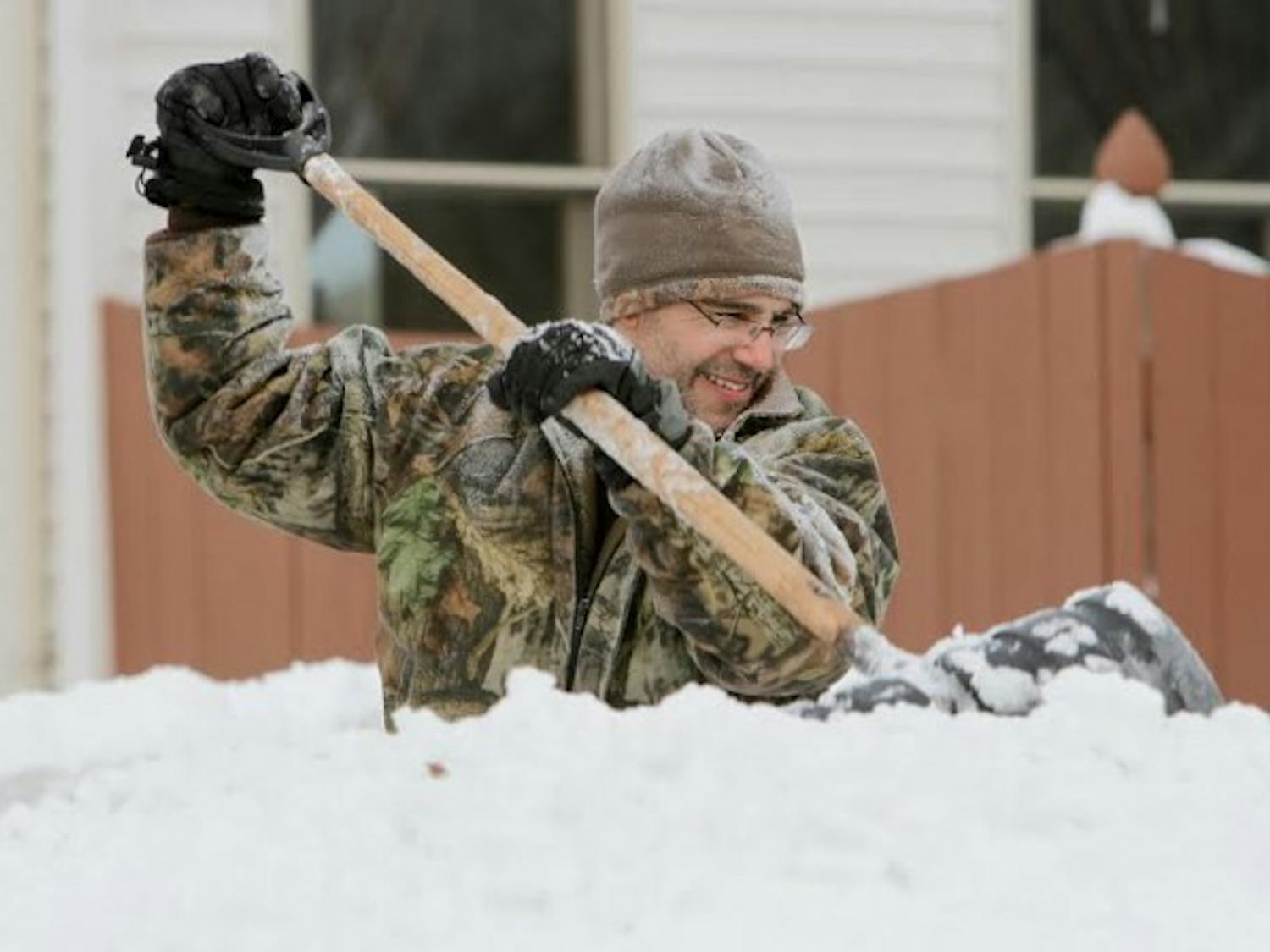 A man in Lancaster struggles to clear his driveway of the more than 60 inches of snow the Buffalo suburb recieved through Wedneday. Some students in the affected areas were frustrated UB didn&#39;t cancel classes before Thursday. Chad Cooper, The Spectrum