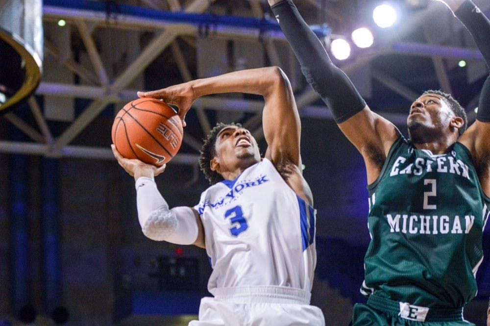 <p>Freshman guard CJ Massinburg&nbsp;attempts to finish over an Eastern Michigan guard during a game last week. Massinburg finished with a game-high 36 points in Buffalo's loss to Ohio Friday night.&nbsp;</p>