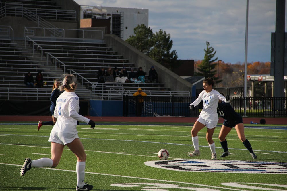 Sophomore Taylor Caridi secures the ball against a defender at Sunday's soccer game.