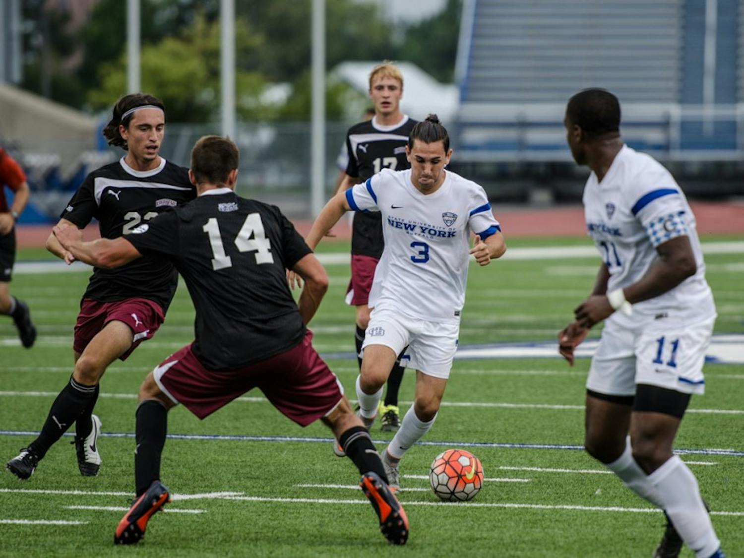 Junior defender Daniel Cramarossa attempts to split two defenders. The Bulls tied with Niagara 2-2 on Sunday, pushing their winless streak to six games.