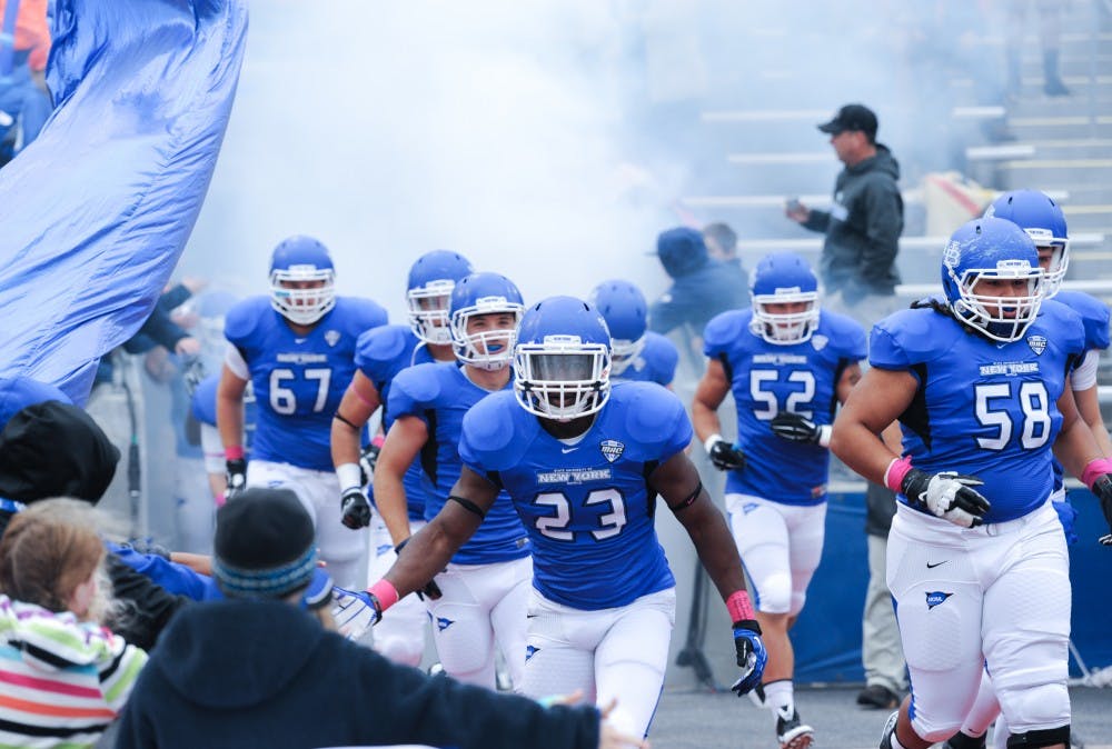 <p>The UB football team runs out of the tunnel of the UB Stadium. The gap between the schools in the Power Five conferences and Mid-Majors like UB seems to be widening, raising the question if it is worth is for schools to have Division I football teams outside of the Power Five.</p>