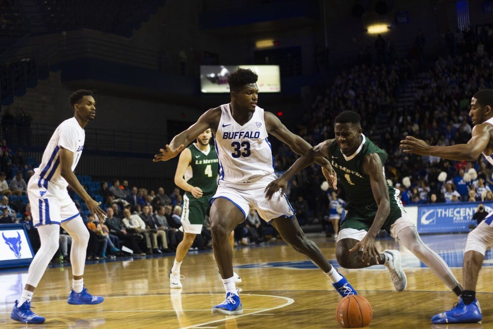 <p>Senior forward Nick Perkins defends against a driving Le Moyne player. Perkins had 18 points in 22 minutes off the bench for the Bulls.</p>