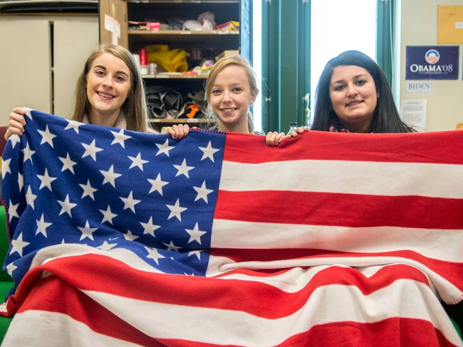 (From left to right)&nbsp;Katie Henshaw, a senior psychology major, Erica Lutz, vice president of UB College Republicans and a junior communication and political science major, and Alexis Ogra, president of UB College Republicans and a sophomore history major, pose with the American flag in the club office.