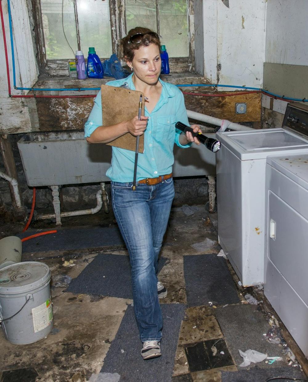 <p>Buffalo housing inspector Cathy Amdur walks through a Northrup Place basement. Buffalo city inspectors and Daniel Ryan, director of Off Campus Student Services, conducted housing blitzes in the University Heights on Saturday, inspecting roughly 35 homes on Winspear Avenue and Northrup Place.</p>
