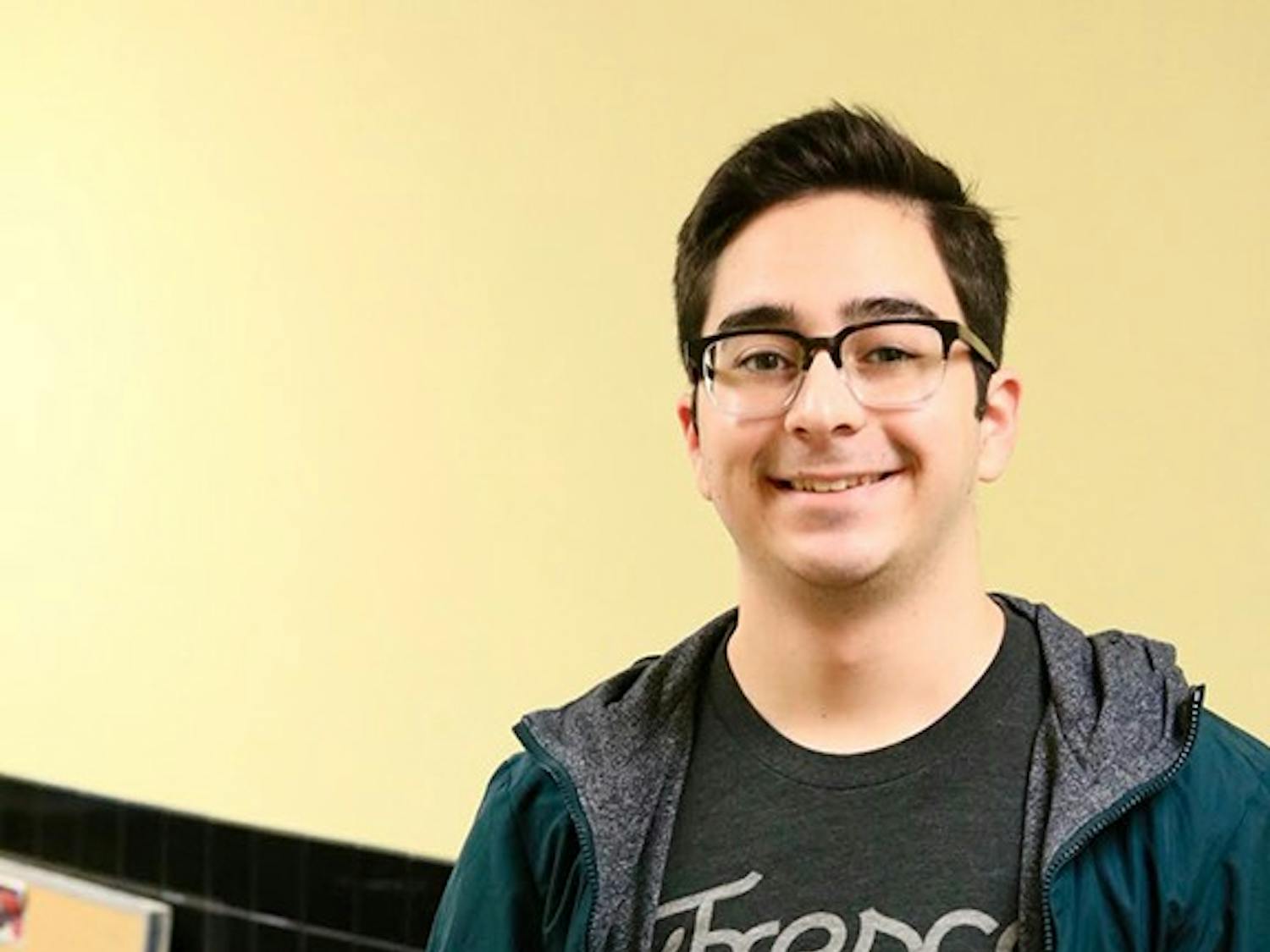 Arthur De Araujo, sophomore computer science major, poses next to the icon for his Lecture Buddy app. The app translates a lecture into text and highlights important keywords.