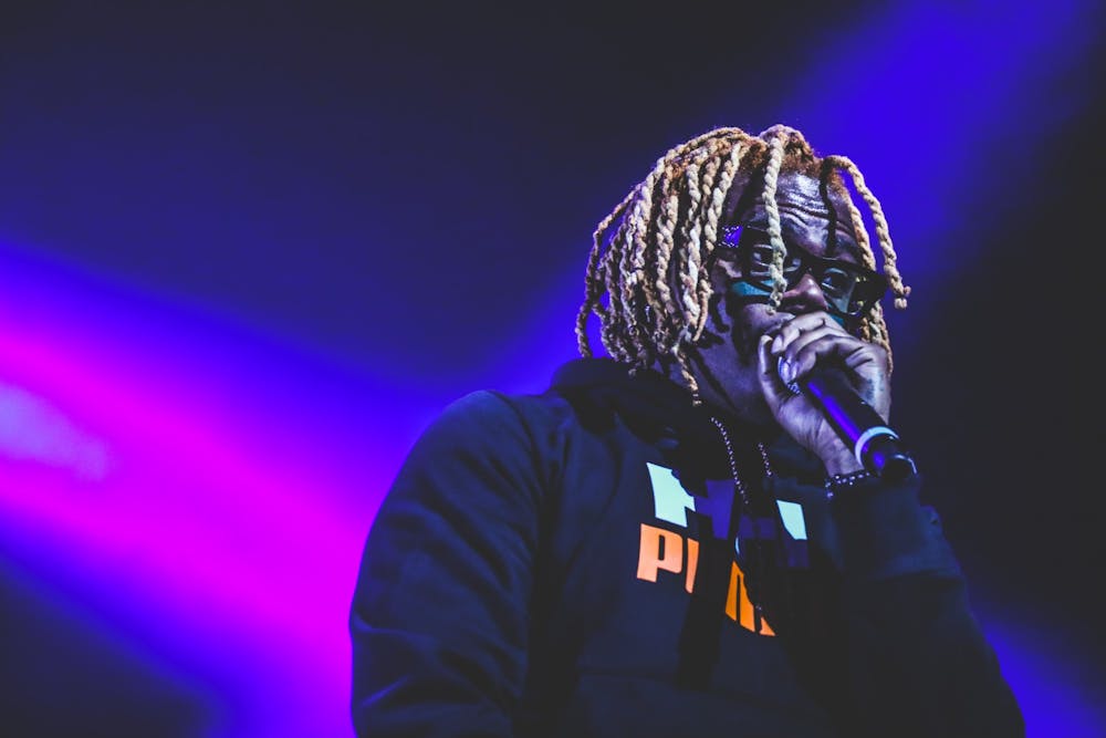 <p>Gunna looks down at students as he croons into the mic at Fall Fest.</p>