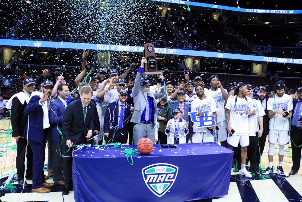 <p>Bulls head coach Nate Oats lifts the MAC tournament trophy over his head. The Bulls have won three of the last four MAC tournaments and are both the MAC regular season and MAC tournament champions this year.</p>