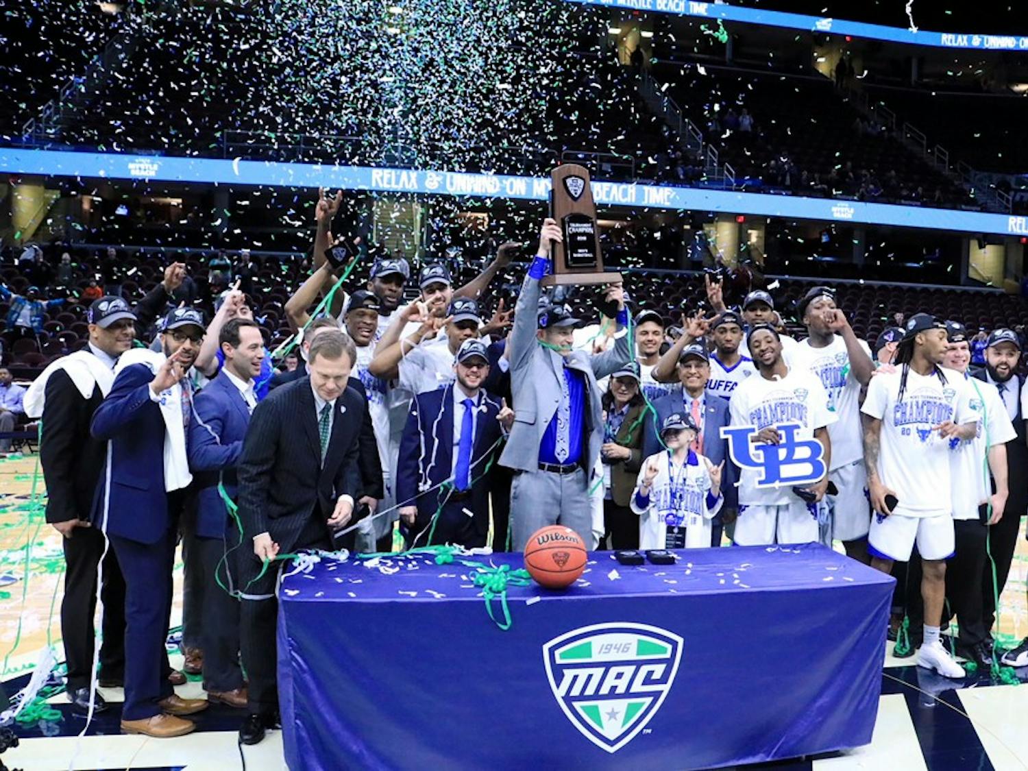 Bulls head coach Nate Oats lifts the MAC tournament trophy over his head. The Bulls have won three of the last four MAC tournaments and are both the MAC regular season and MAC tournament champions this year.