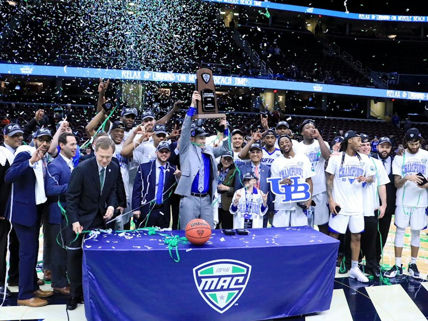 Bulls head coach Nate Oats lifts the MAC tournament trophy over his head. The Bulls have won three of the last four MAC tournaments and are both the MAC regular season and MAC tournament champions this year.