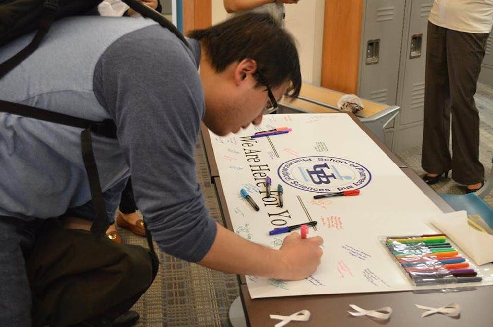 <p>A student signs the Student National Pharmaceutical Association (SNPhA) and&nbsp;Lambda Kappa Sigma's banner that will be sent to&nbsp;the pharmacy school in Paris Descartes University. The&nbsp;organizations&nbsp;are&nbsp;fundraising money for victims of the Paris attacks.&nbsp;</p>