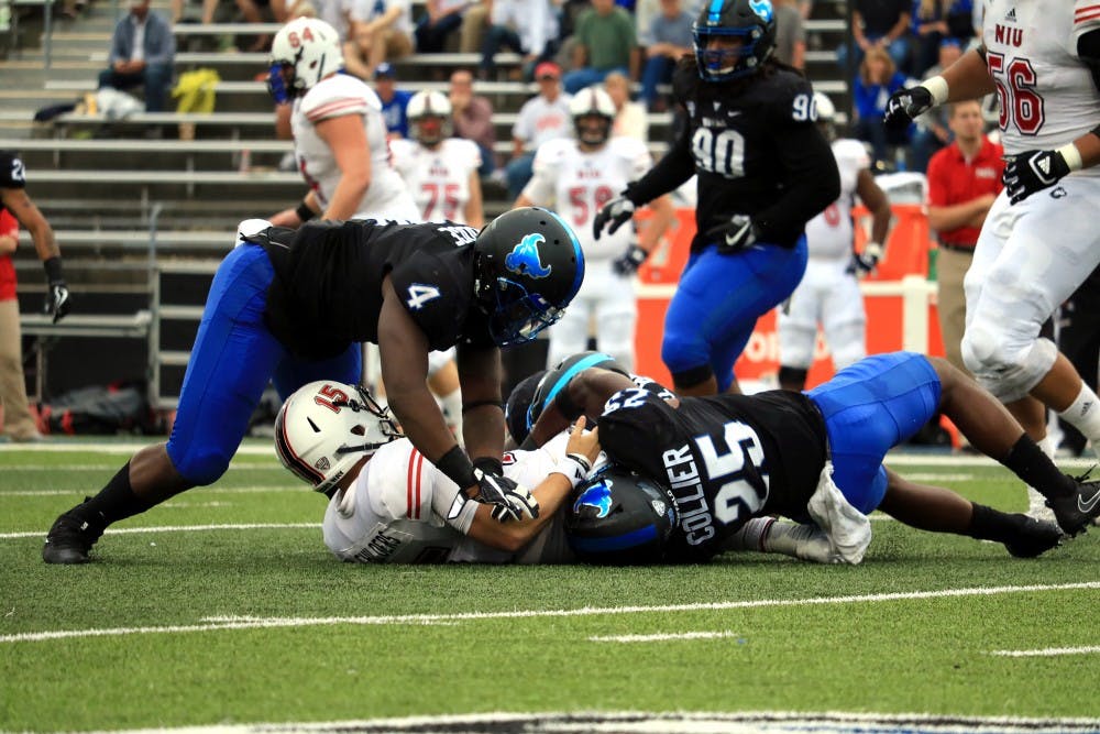 <p>Junior linebacker Khalil Hodge and senior safety Ryan Williamson tackle NIU's quarterback. Hodge and Williamson are the two leading tacklers for the Bulls defense.</p>