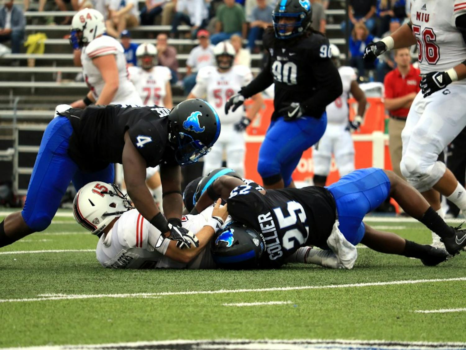 Junior linebacker Khalil Hodge and senior safety Ryan Williamson tackle NIU's quarterback. Hodge and Williamson are the two leading tacklers for the Bulls defense.