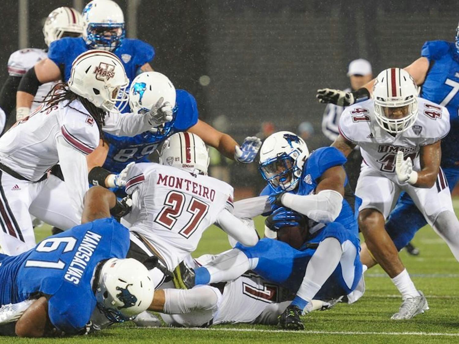 Junior running back Jordan Johnson (carrying ball) is tackled during Buffalo's 31-26 loss to Massachusetts Friday at UB Stadium. The loss officially ends the Bulls' season. 