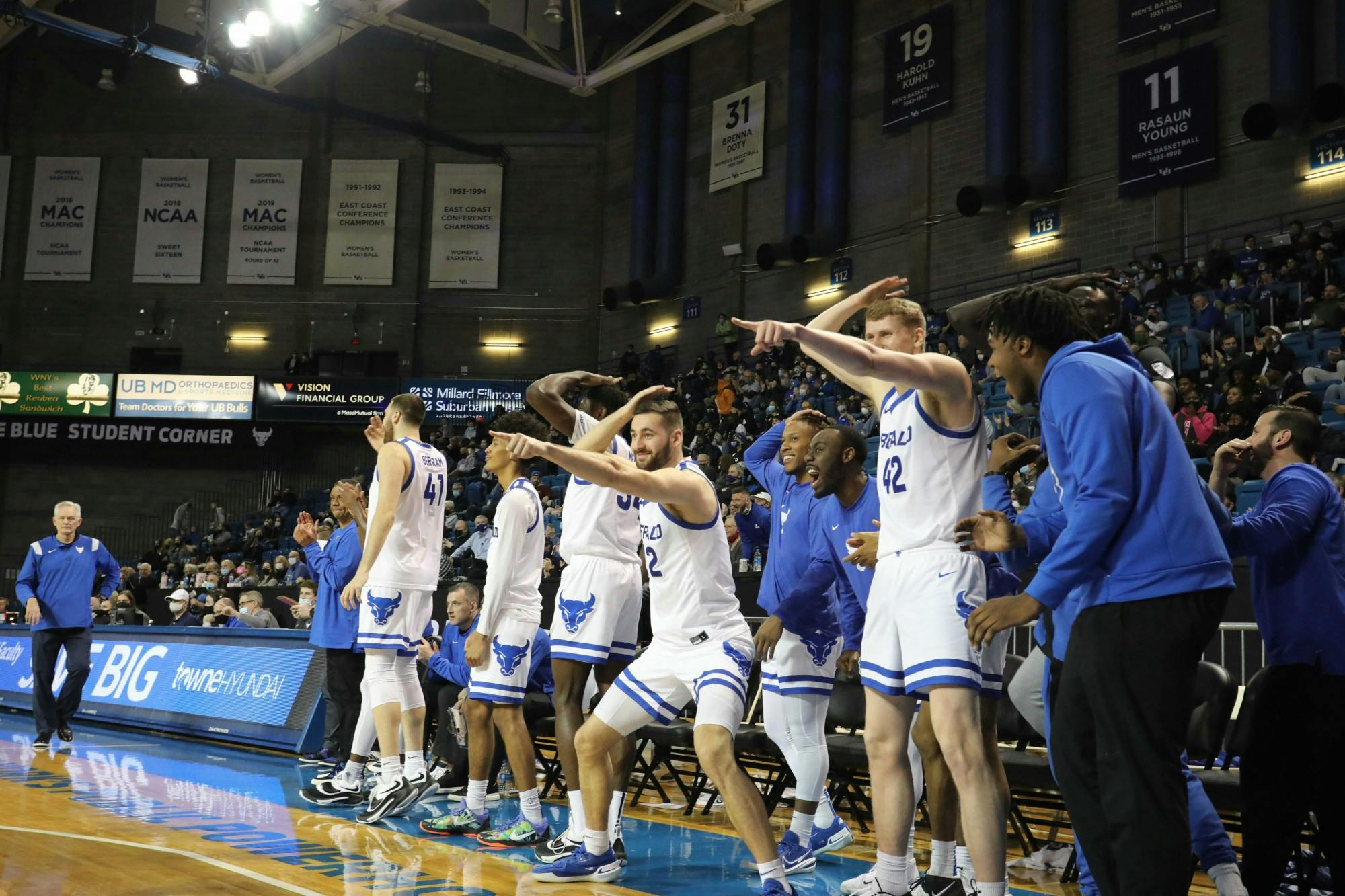 Center David Skogman (42), forward Lucas Saleh (22) and forward Josh Mballa (34) celebrate on the sidelines during a recent game.