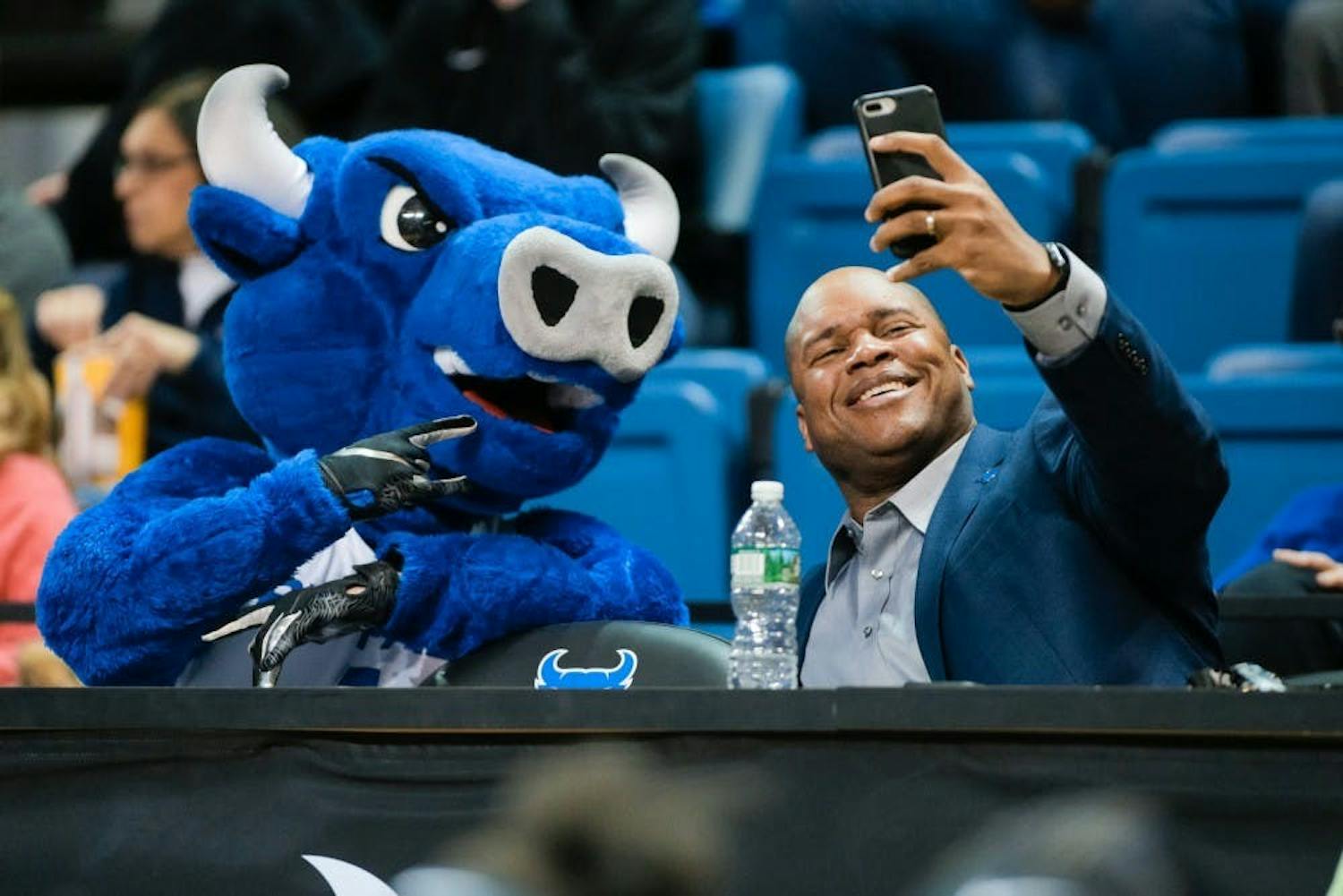 UB Athletic Director Mark Alnutt takes a selfie with Victor E. Bull at a basketball game.