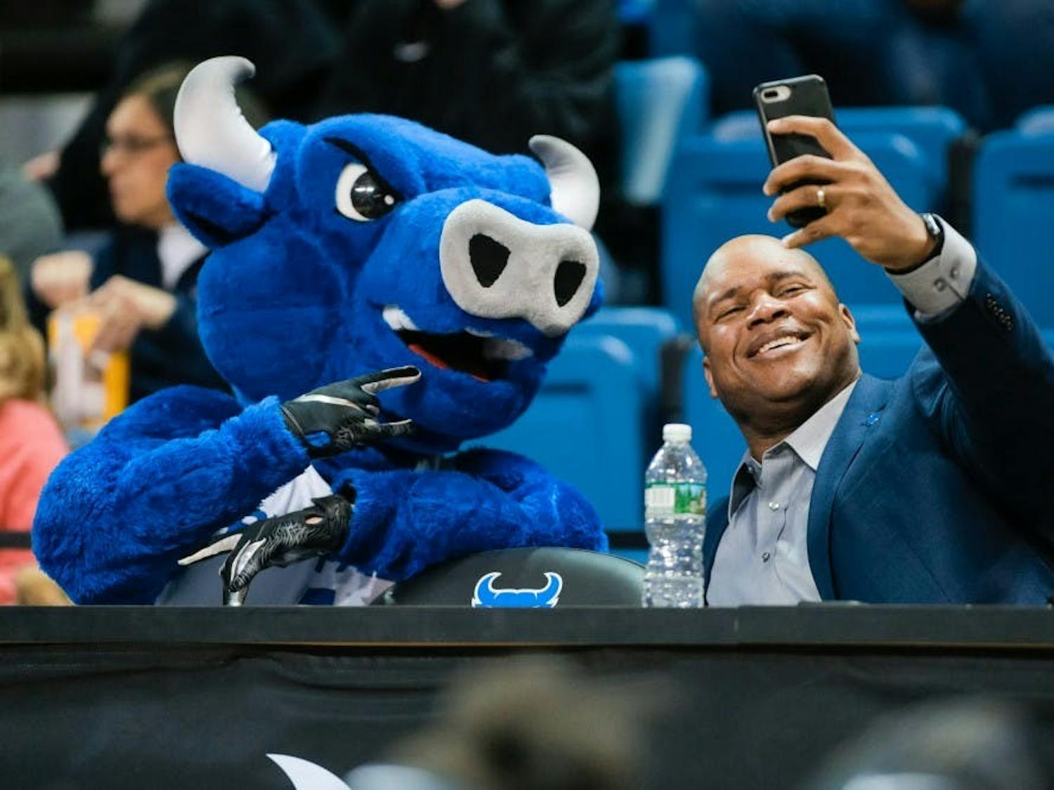UB Athletic Director Mark Alnutt takes a selfie with Victor E. Bull at a basketball game.