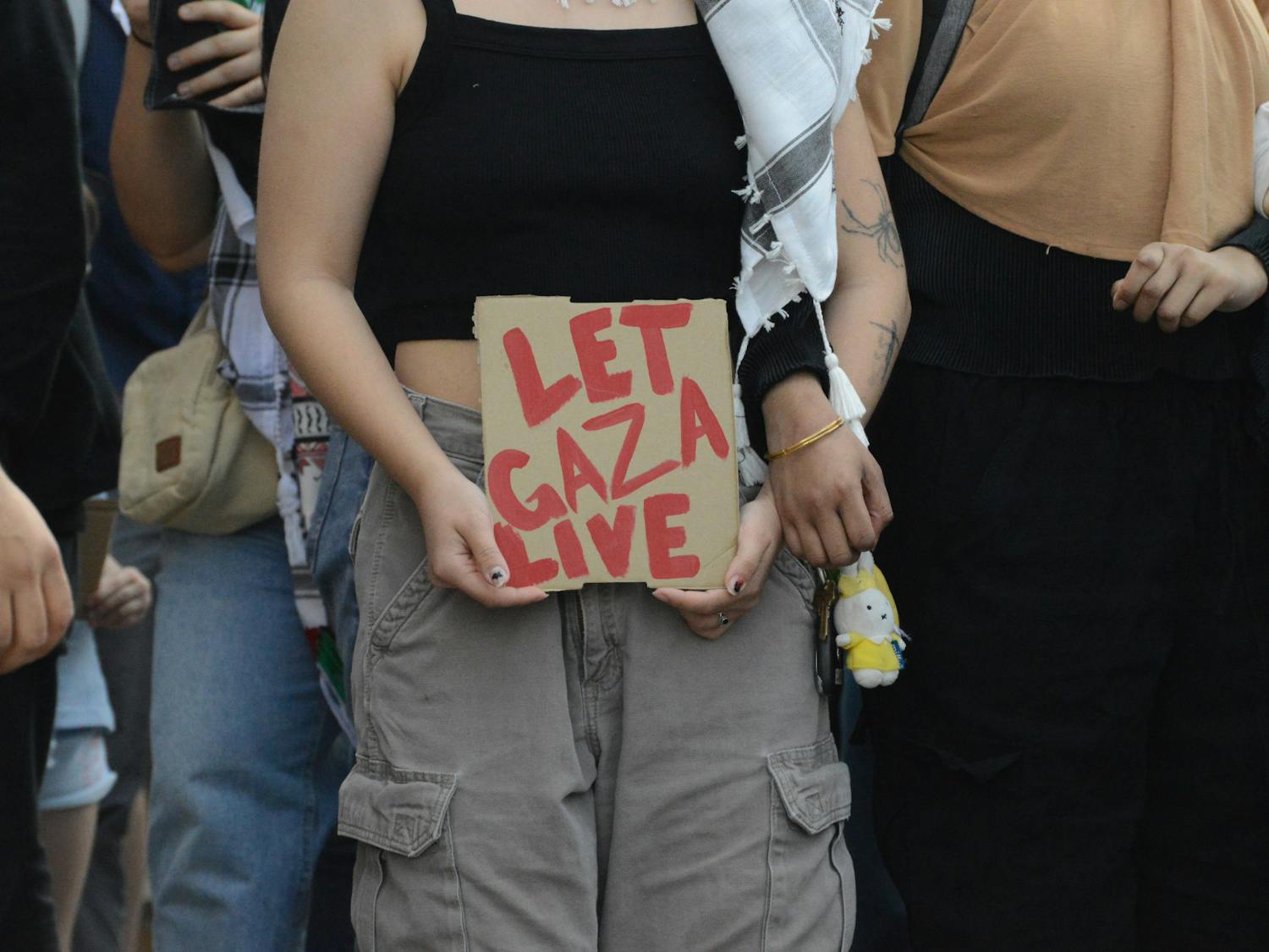 A protestor holds a "let Gaza live" sign at Friday's protest.