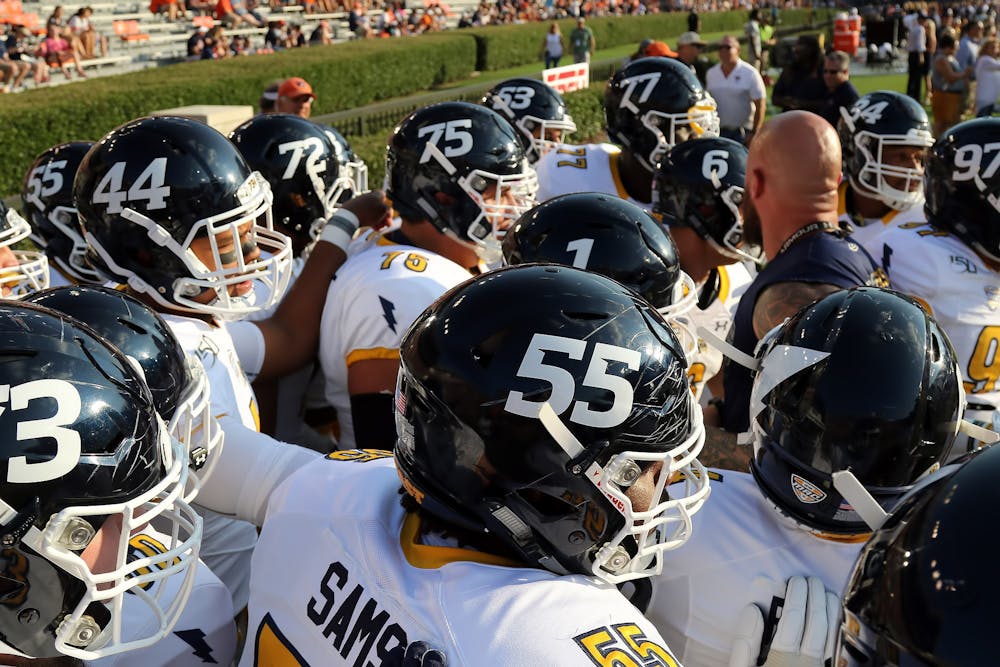 <p>Golden Flashes players huddle around their coach for instructions.</p>
