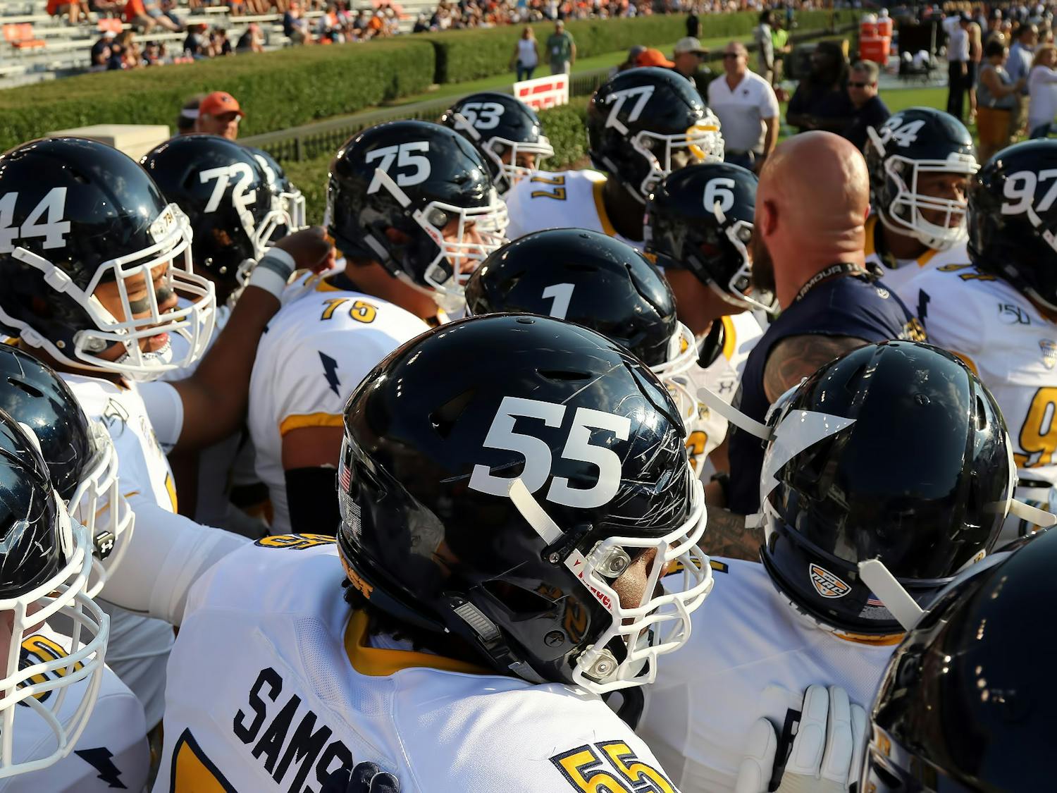 Golden Flashes players huddle around their coach for instructions.