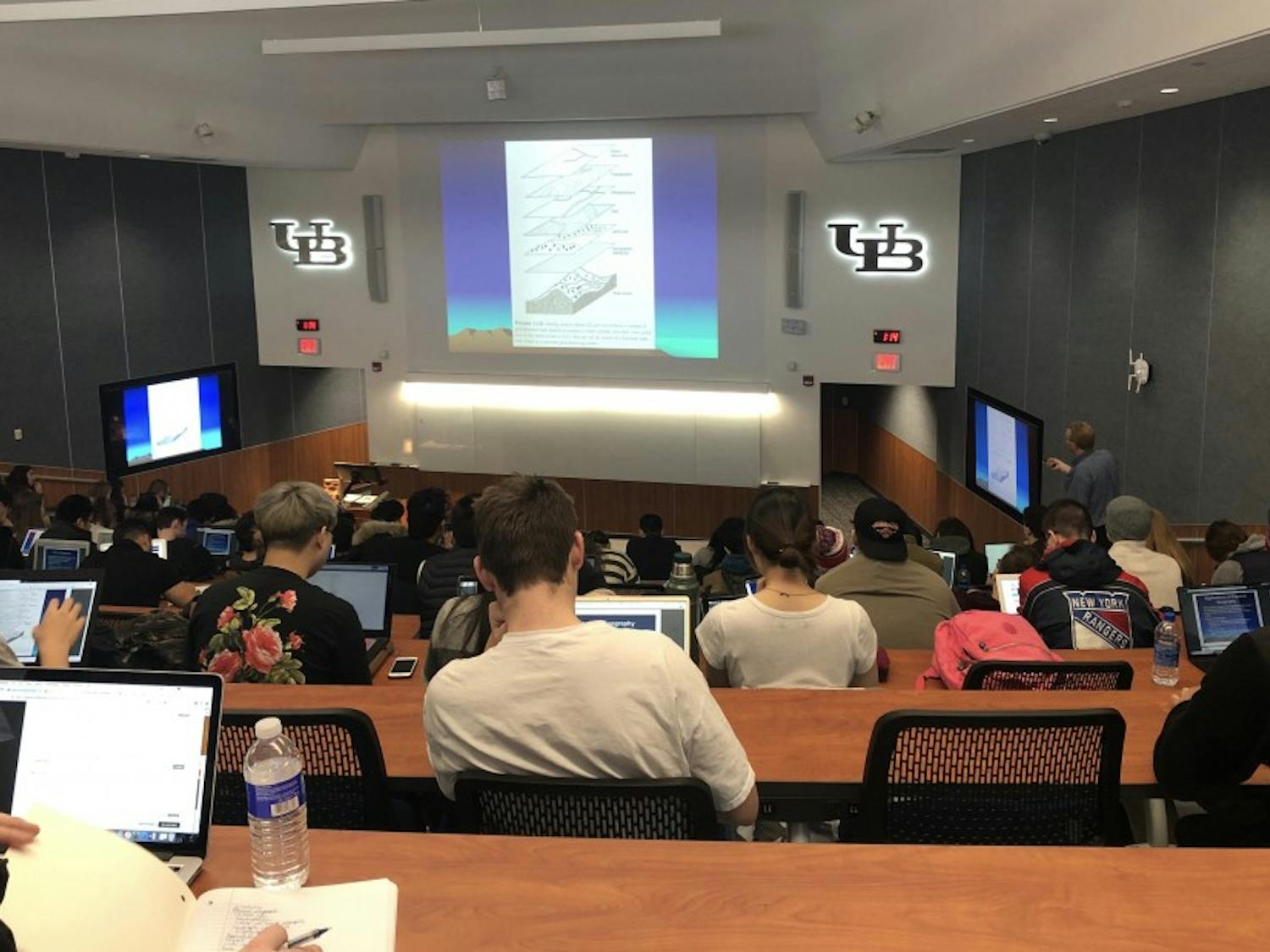 Students taking notes during a large lecture in 170 Fillmore Hall. Students have extra time this semester to add a class to their schedule, after the add/drop period was pushed back following last week’s storm.