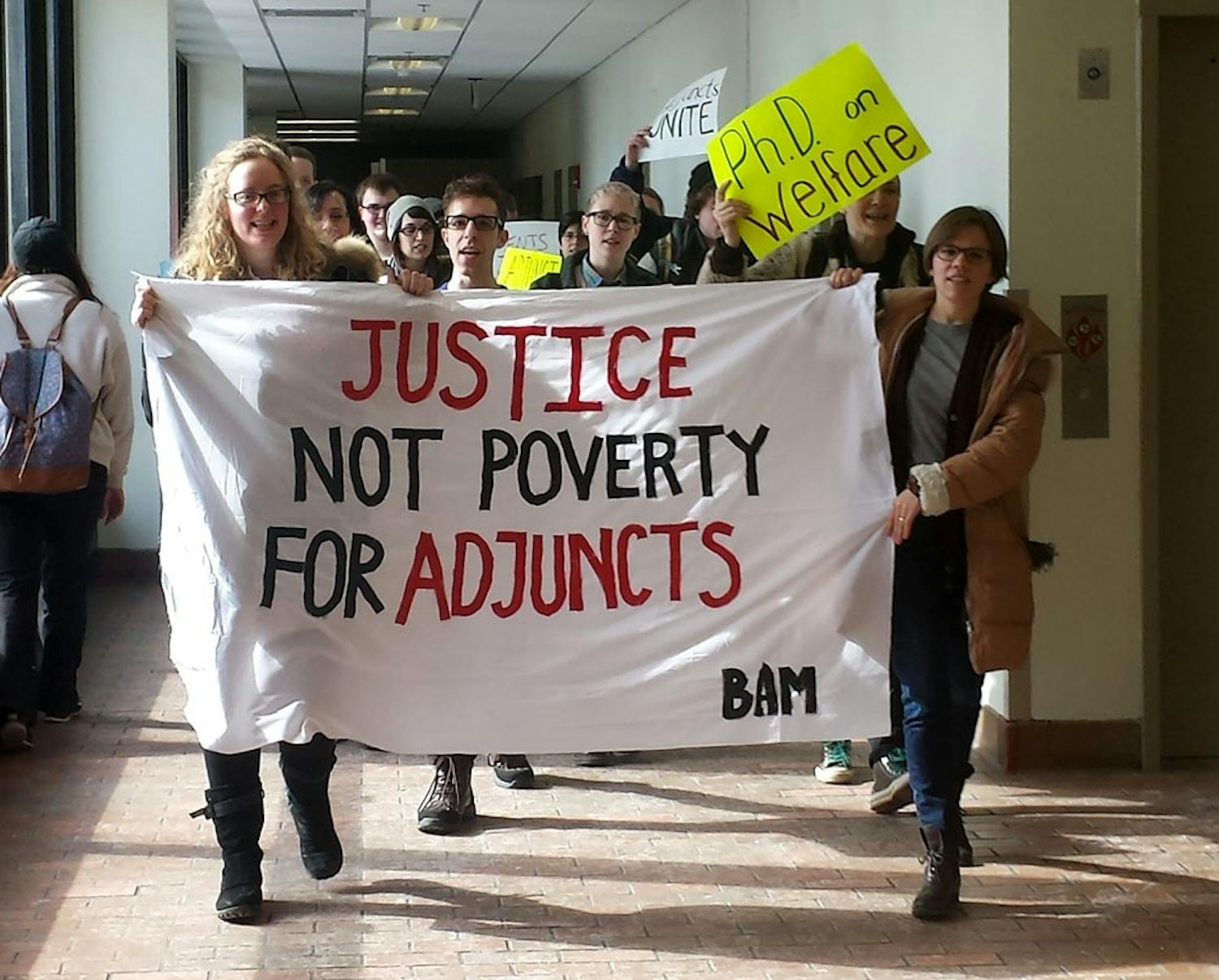Approximately 50 professors and students march through Capen Hall on Wednesday afternoon advocating for better pay and treatment for adjunct professors as a part of National Adjunct Walkout Day. 