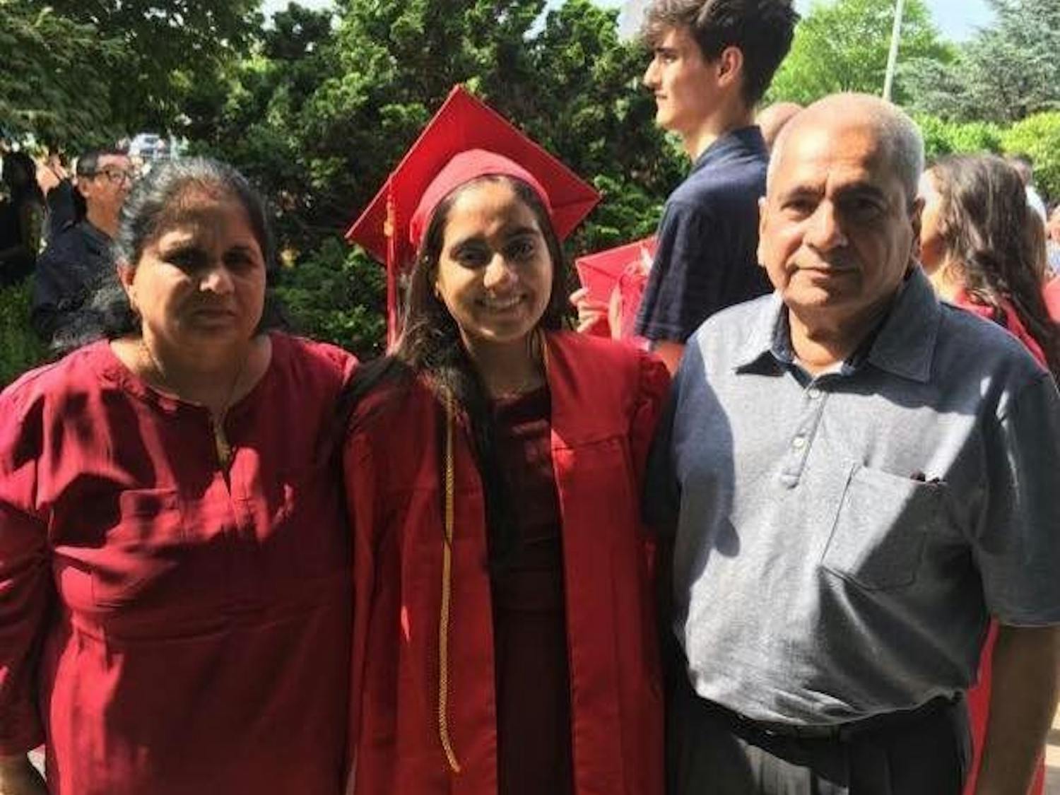 Minnoli Aya (center) with her mother Madhvi and her father at her high school graduation.