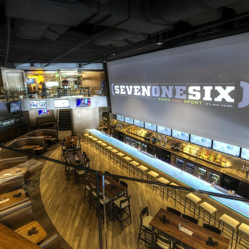 <p>The main bar area at (716) Food and Sport. The bar features a 38-foot-long main TV along with an additional 70 others.</p>
