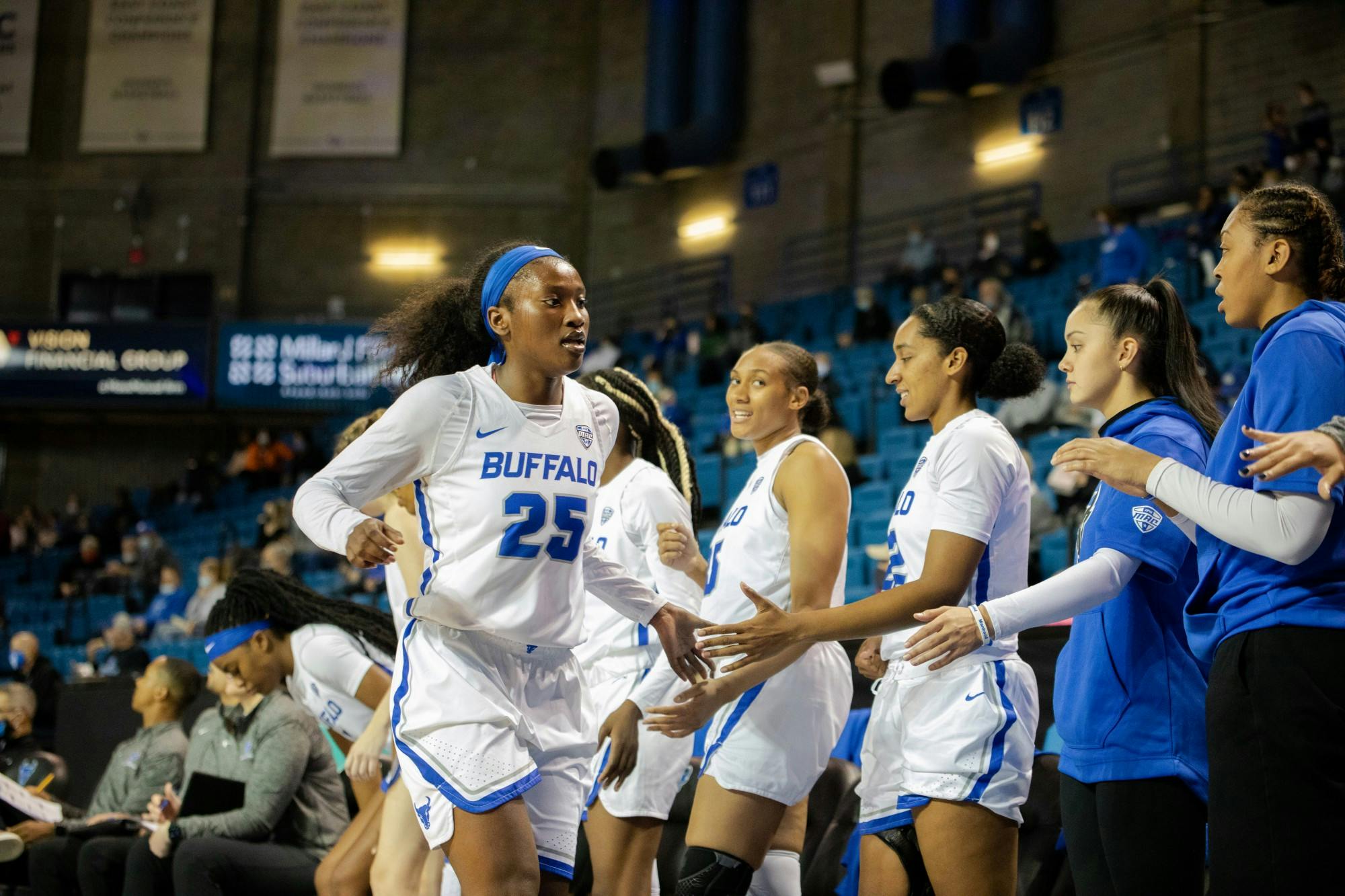 Senior forward Adebola Adeyeye (25) high-fives her teammates during a regular season game.