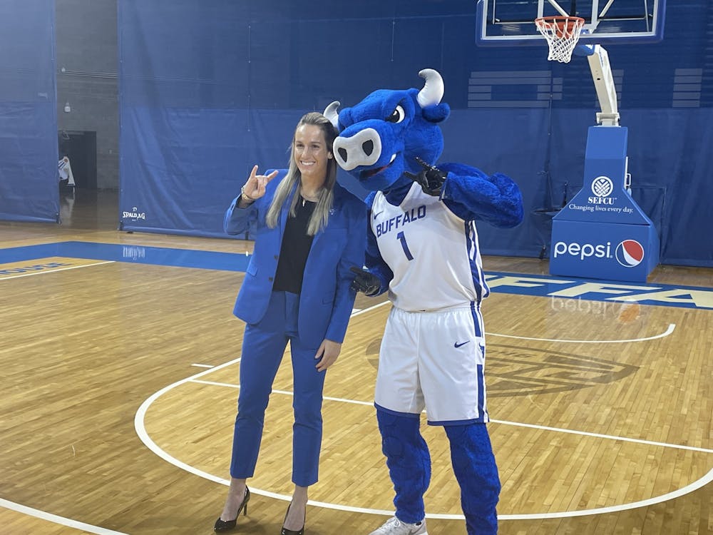 Women’s basketball head coach Becky Burke poses for a photo with Victor E. Bull.