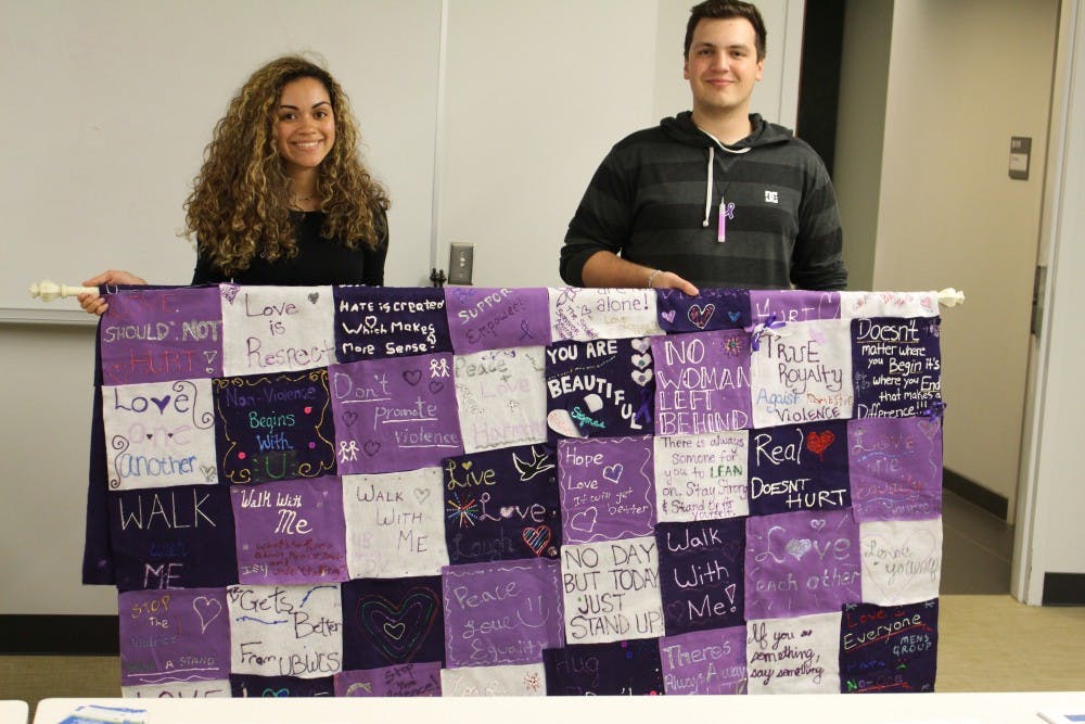 <p>Stephanie Vazquez (left) and Jamie Core (right) hold a quilt made by UB students and faculty to raise awareness on sexual violence as part of the annual Take Back the Night event. </p>