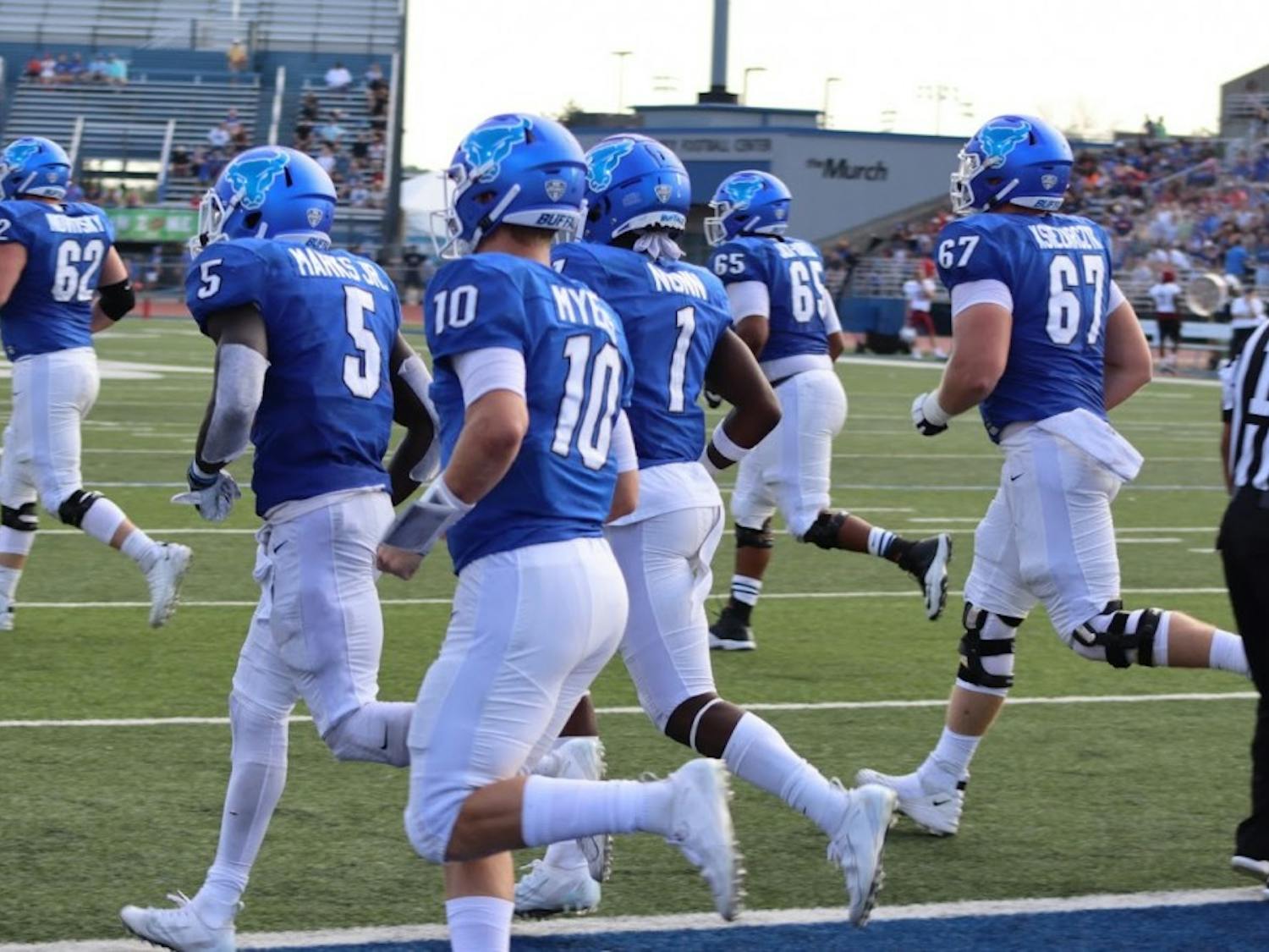 The Bulls run on the field at Temple.