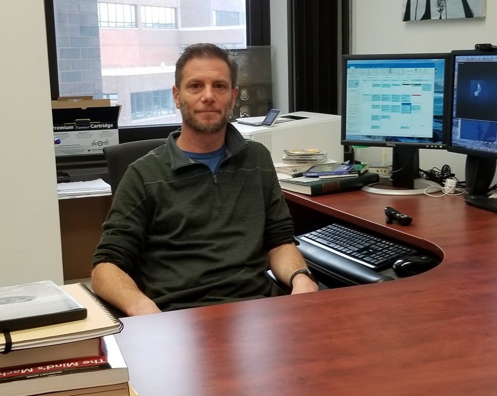 Dr. Derek Daniels sits at his desk in Hochstetter Hall. Daniels said the media plays an important role in how scientific work is perceived by the general public.