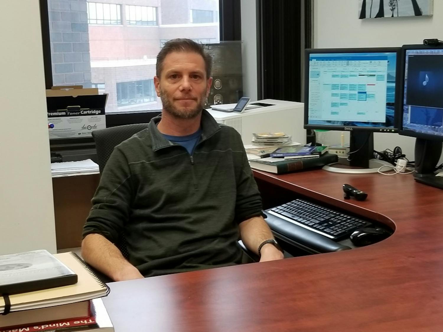 Dr. Derek Daniels sits at his desk in Hochstetter Hall. Daniels said the media plays an important role in how scientific work is perceived by the general public.