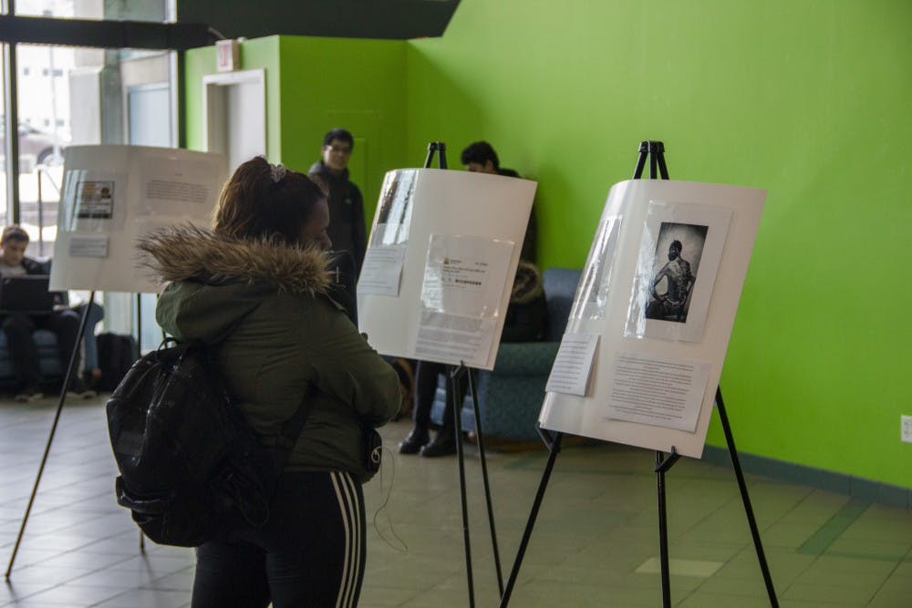<p>Students walk through the Student Association’s museum for Black History Month in the SU lobby. The Black Student Union, African Student Association and SA are trying to spread awareness for Black History Month.</p>