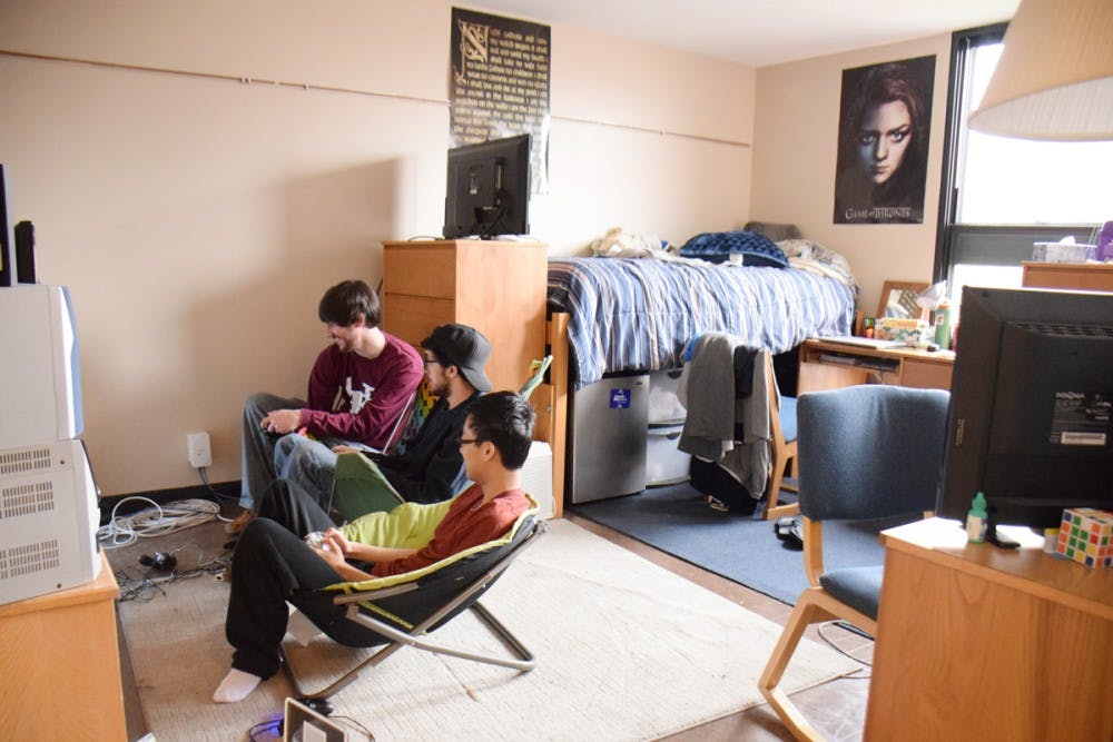 <p>Roommates (right to left) Kevin Wu, Drew Wentka and Matt Holder play video games together in their Richmond dorm room.</p>